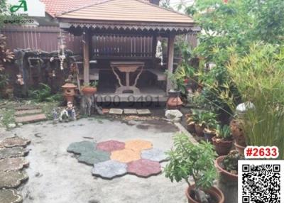 Cozy outdoor garden with traditional wooden gazebo and decorative potted plants