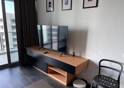 Modern living room with a large television and balcony access