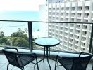 Ocean view from an apartment balcony with seating arrangement