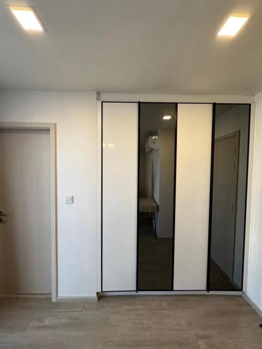 Modern bedroom with large mirrored closet and LED lighting