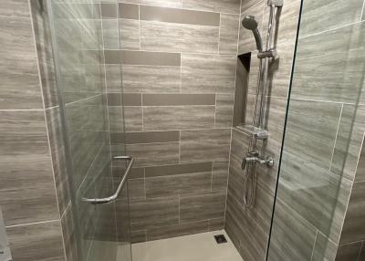 Modern bathroom with glass shower enclosure and tiled walls