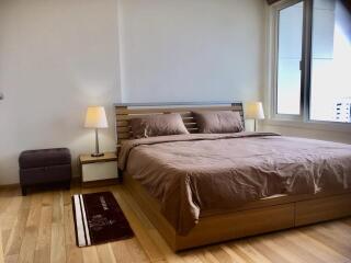 Cozy bedroom with wooden flooring and natural light