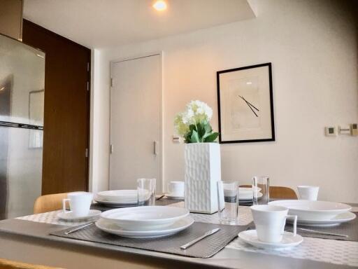 Modern dining area with set table and wall art