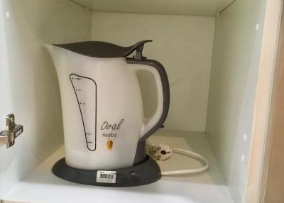 Electric kettle inside a kitchen cabinet