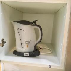 Electric kettle inside a kitchen cabinet