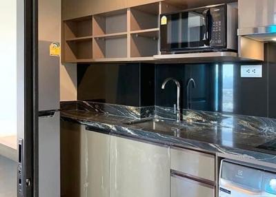 Modern kitchen with stainless steel appliances and dark cabinets