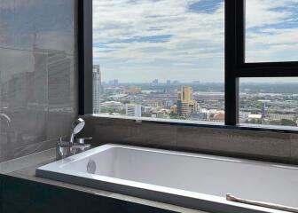 Bathroom with a large window overlooking the city skyline