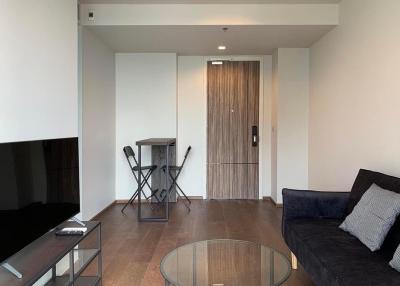 Modern living room interior with a large flat-screen TV, comfortable sofa, and elegant glass coffee table