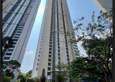 exterior view of a modern high-rise residential building with surrounding greenery