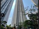 exterior view of a modern high-rise residential building with surrounding greenery