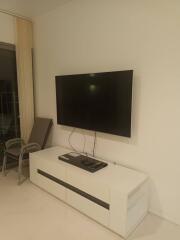 Modern living room with wall-mounted TV and white entertainment unit