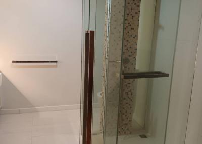 Modern bathroom with glass shower enclosure and tiled walls