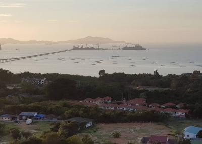 Panoramic view of a coastal area with bridge and ships at dusk