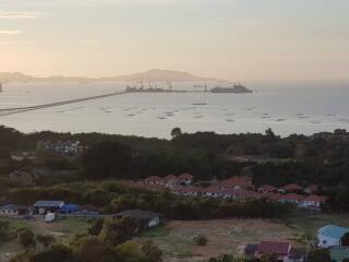 Panoramic view of a coastal area with bridge and ships at dusk