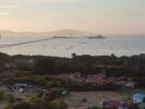 Panoramic view of a coastal area with bridge and ships at dusk