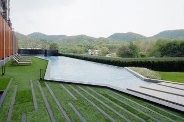 Modern home exterior with an infinity pool and lush greenery