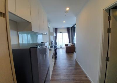 Modern apartment interior showing open kitchen leading to a cozy living room