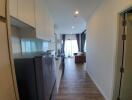 Modern apartment interior showing open kitchen leading to a cozy living room