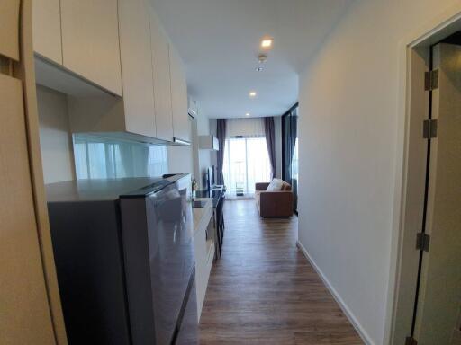 Modern apartment interior showing open kitchen leading to a cozy living room