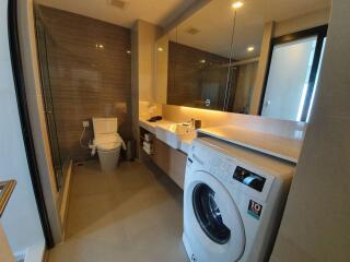 Modern bathroom with washer and glass shower door