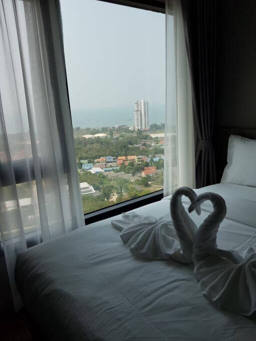 Cozy bedroom with a scenic view overlooking the city and coastal area