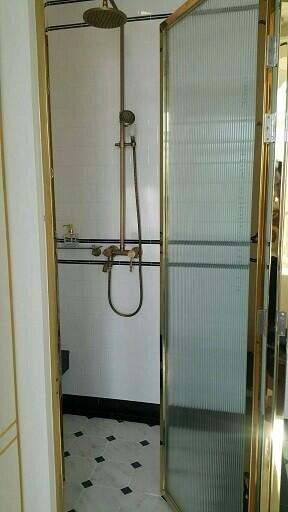 Compact bathroom with glass shower enclosure and classic fixtures