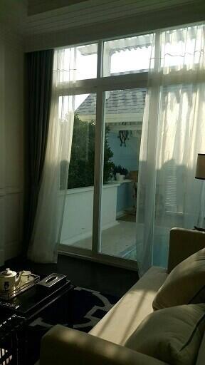 Cozy bedroom with natural light coming through large windows and sheer curtains