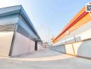 Exterior view of modern industrial buildings with vivid roofs and gated entrances