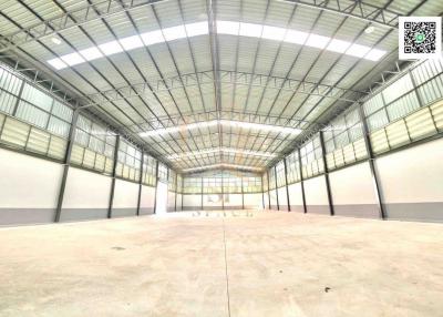 Spacious empty warehouse interior with high ceiling and natural lighting