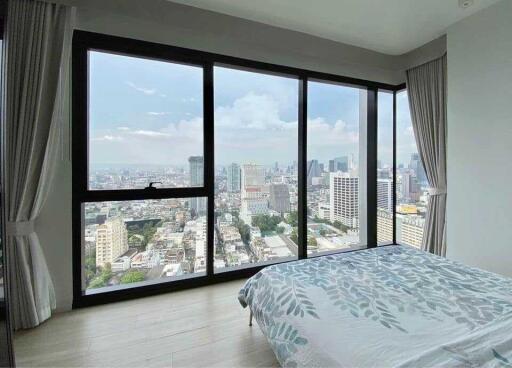 Spacious bedroom with large windows offering city views