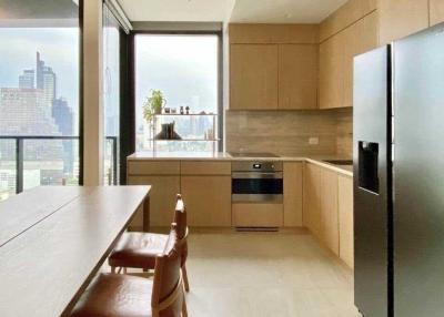 Modern kitchen with dining area, large windows, and city view
