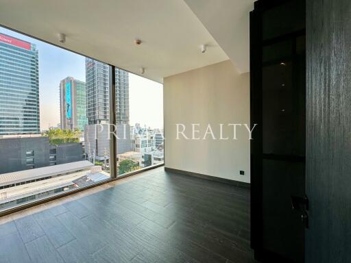 Empty bedroom with dark wooden flooring and city view