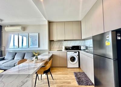 Modern kitchen integrated with living space featuring stainless steel appliances