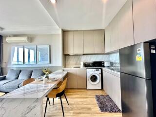 Modern kitchen integrated with living space featuring stainless steel appliances