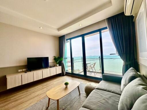 Spacious living room with large window overlooking the sea