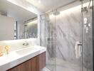 Modern bathroom with marble tiles and glass shower enclosure