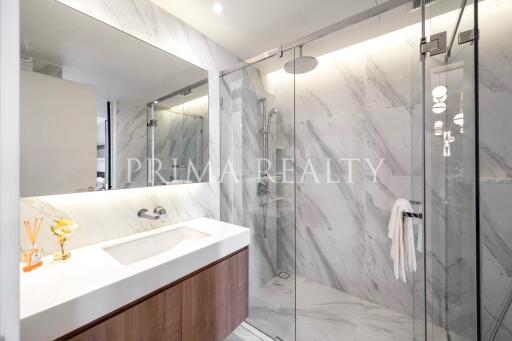 Modern bathroom with marble tiles and glass shower enclosure