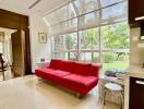 Modern living room with large windows and red sofa