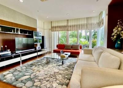 Spacious and modern living room with natural stone flooring and large windows