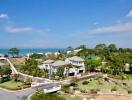 Aerial view of a coastal residential area with lush greenery