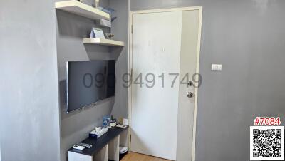 Compact bedroom with mounted television and shelf storage space