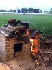 Outdoor traditional cooking setup with brick stove in a rural setting