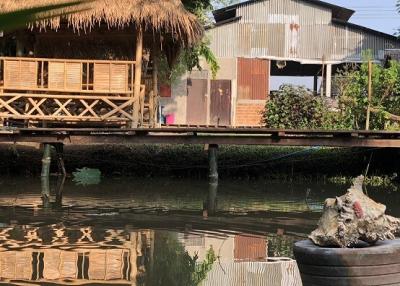 Rustic waterfront property with traditional hut and reflection on water