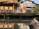 Rustic waterfront property with traditional hut and reflection on water