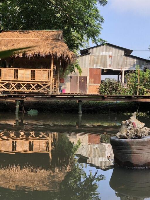 Rustic waterfront property with traditional hut and reflection on water