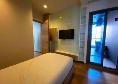 Modern bedroom with large window and wall-mounted TV