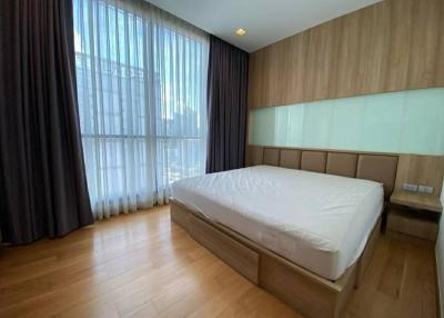 Modern bedroom with large bed and wood paneling