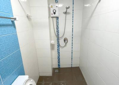 Modern bathroom with white tiles and an electric shower