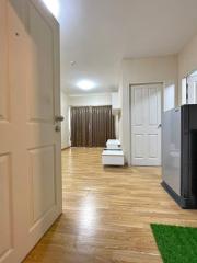 Bright hallway interior with hardwood floors leading to a room with closed curtains