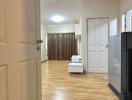 Bright hallway interior with hardwood floors leading to a room with closed curtains